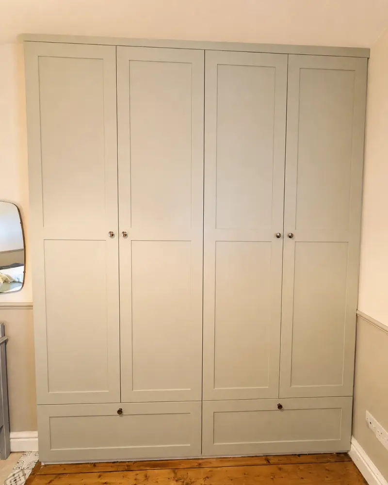 Full-height sage fitted wardrobes with base drawers, built floor to ceiling