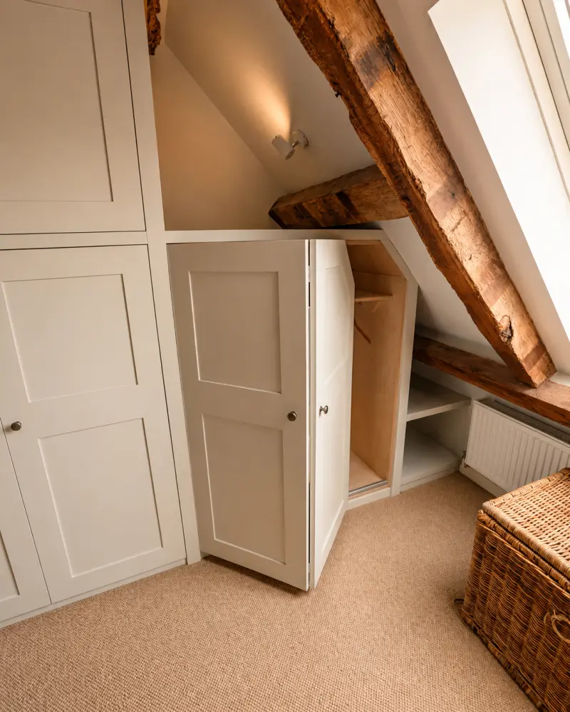 Bespoke fitted wardrobes scribed into a sloping-ceiling bedroom in the Brecon Beacons