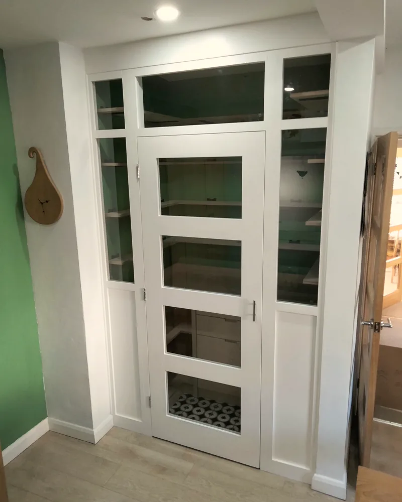 Full-height glazed larder cupboard with white frames and open shelving