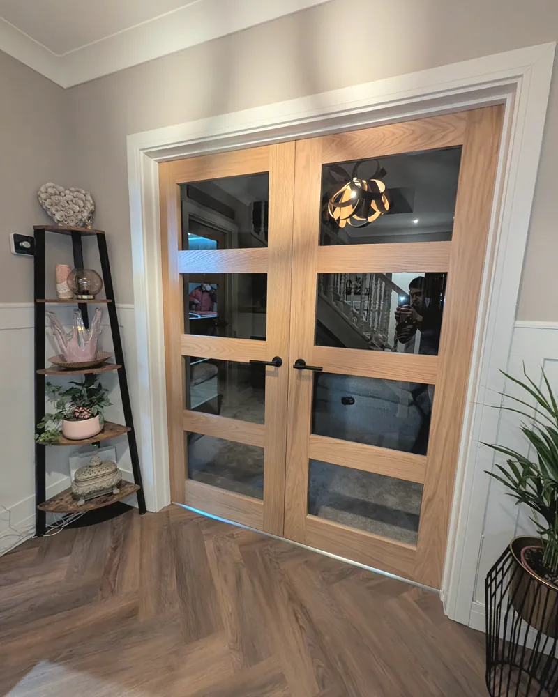 Oak framed glazed double doors hung between a hallway and living room
