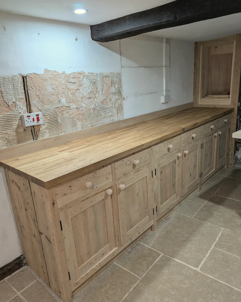 Long run of pine base cupboards with a solid oak worktop