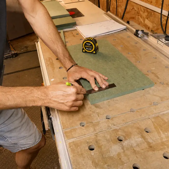 Marking out a panel with a square and tape measure