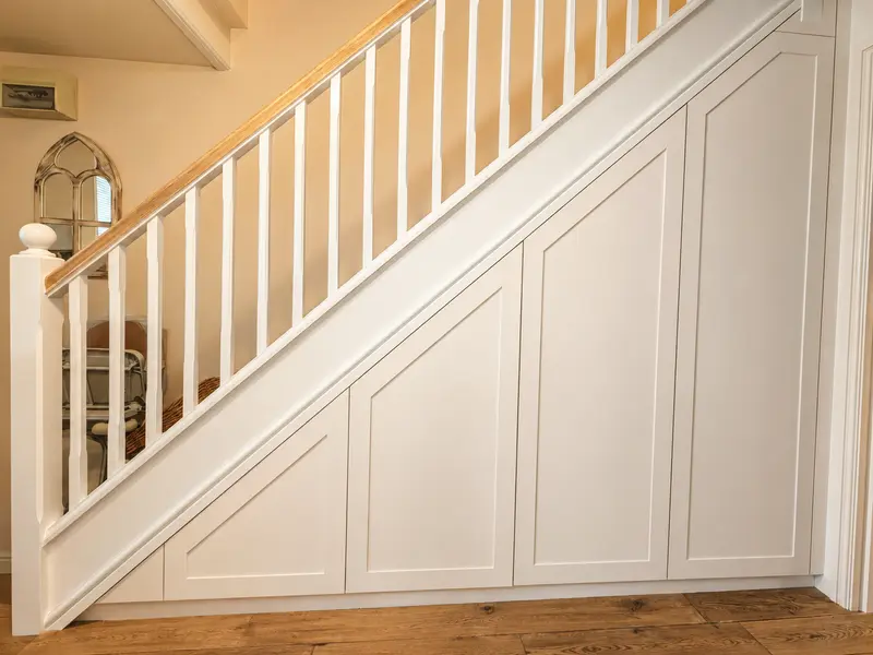 Cream Shaker-style under-stairs doors following the staircase in a Crickhowell home