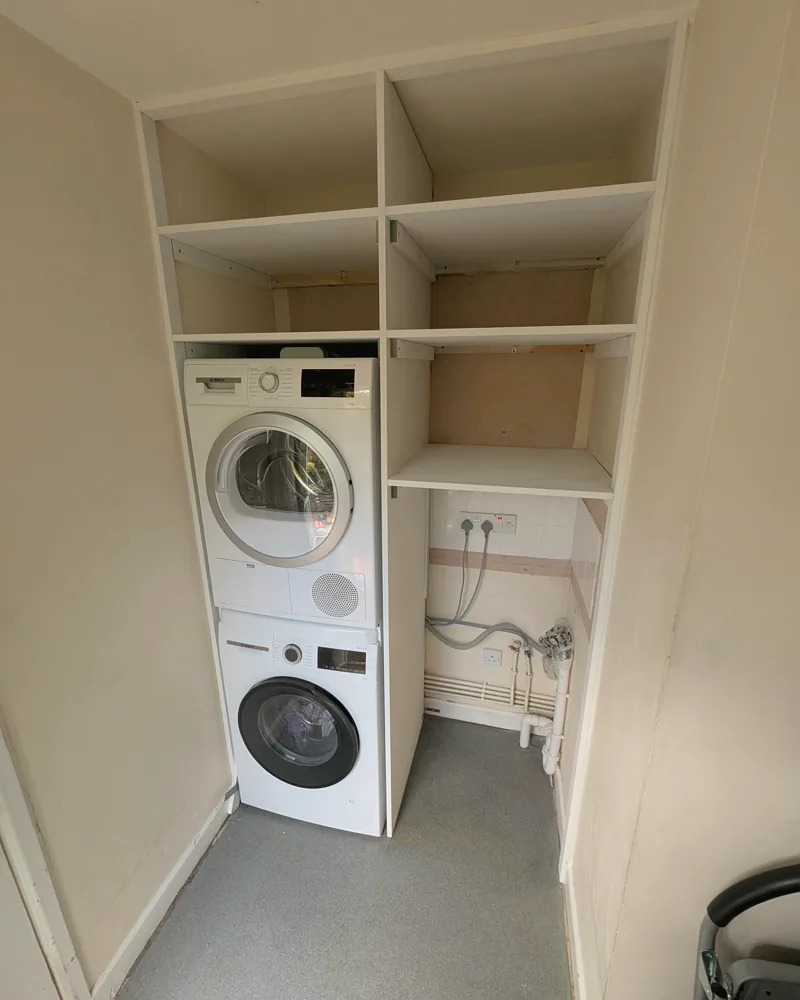 Fitted utility shelving built around a stacked washer and dryer