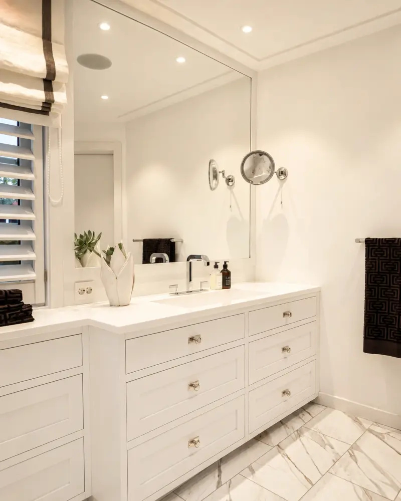 A bespoke bathroom vanity unit with drawer storage and a wall-mounted mirror