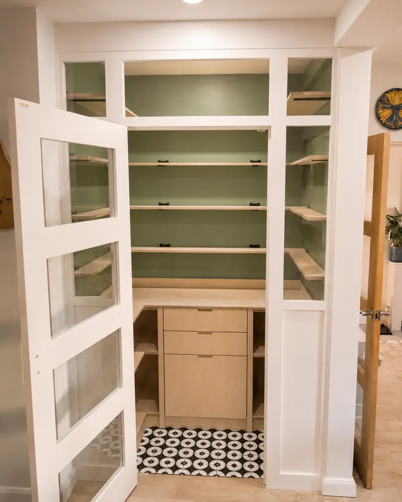 Walk-in pantry with fitted shelving, glazed door and birch drawer unit